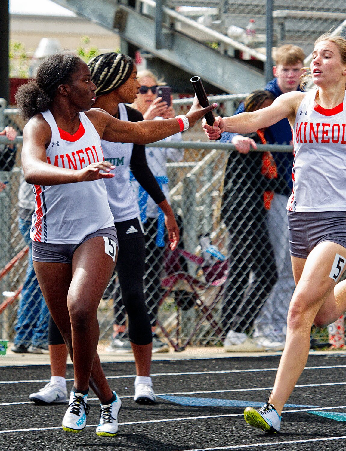 Raylie Peebles passes the baton to Shylah Kratzmeyer for the second leg of the 1600m relay final Saturday in Whitehouse. [more prelims and finals photos]